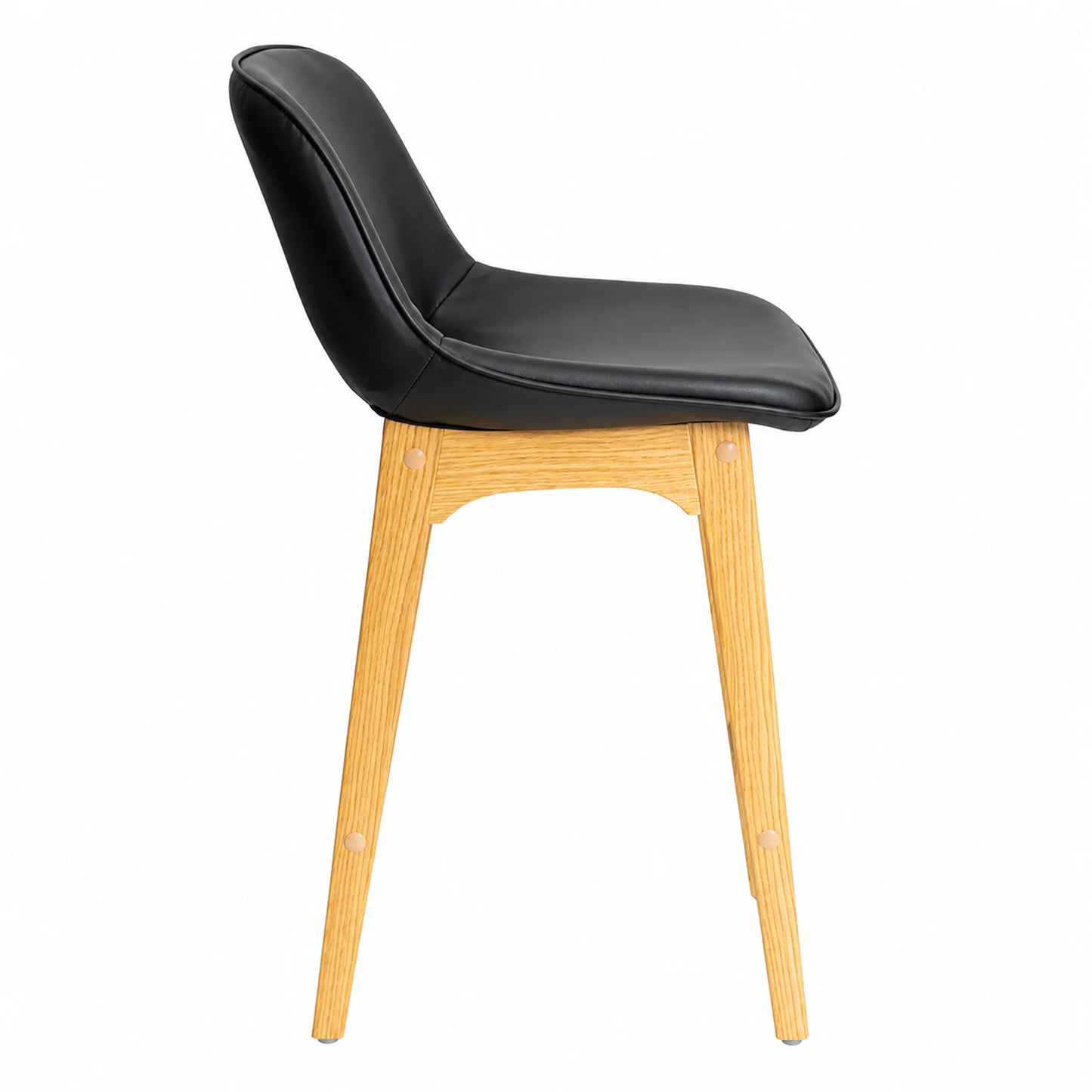 A modern side chair with a black faux-leather upholstered seat and curved backrest, supported by four tapered light oak legs, shown from a side profile view on a white background.