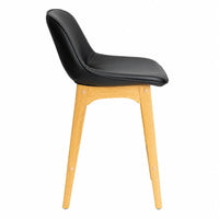 A modern side chair with a black faux-leather upholstered seat and curved backrest, supported by four tapered light oak legs, shown from a side profile view on a white background.