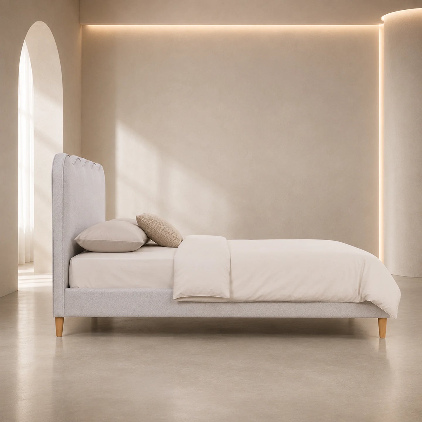 A minimalist light gray upholstered bed with a tall tufted headboard, shown in a softly lit neutral bedroom setting with cream bedding, two pillows, and warm ambient lighting.