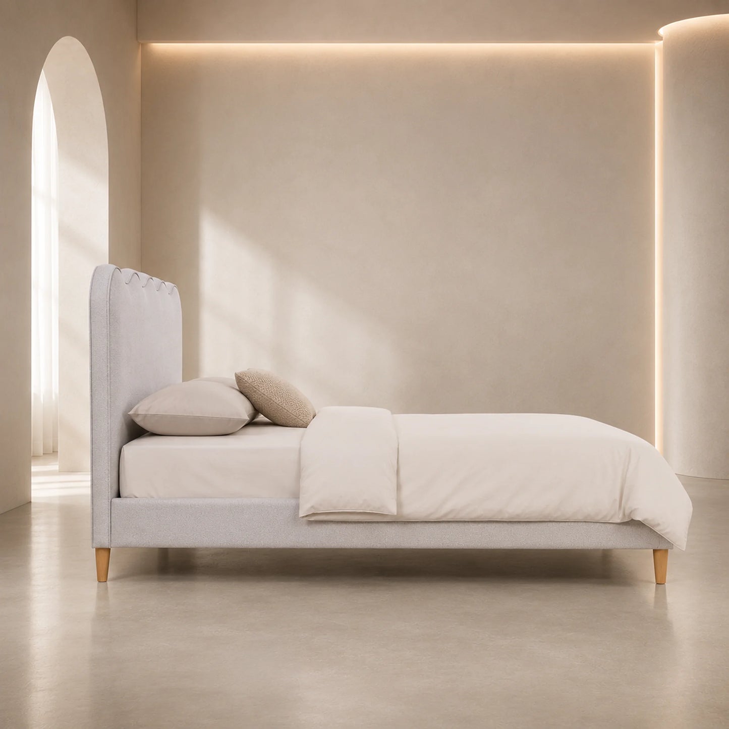 A minimalist light gray upholstered bed with a tall tufted headboard, shown in a softly lit neutral bedroom setting with cream bedding, two pillows, and warm ambient lighting.