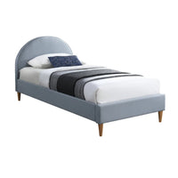 Gray upholstered bed with white bedding and blue pillows on a white background