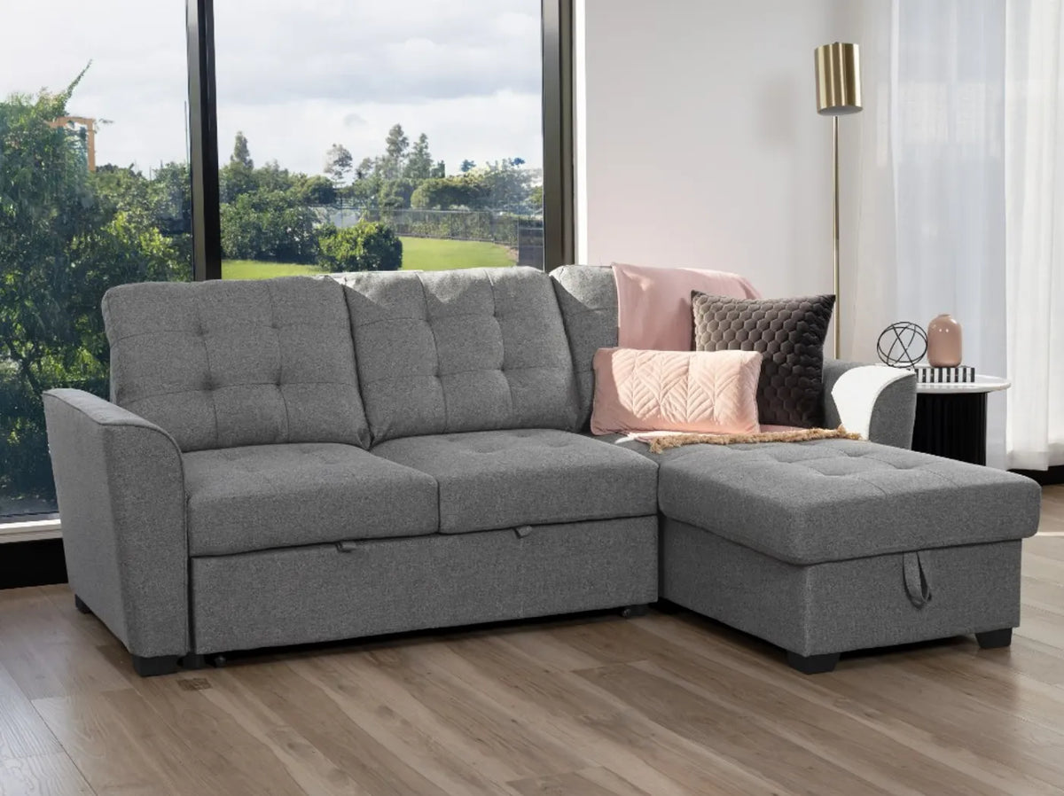 Aurore 2 seater sofa bed with grey upholstery, button-tufted cushions and storage chaise shown on the right side of the image