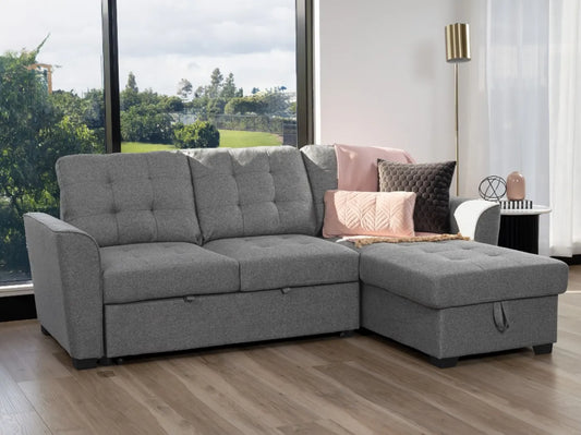 Aurore 2 seater sofa bed with grey upholstery, button-tufted cushions and storage chaise shown on the right side of the image
