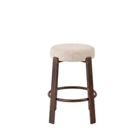 A single bar stool with a round upholstered seat in a light beige fabric and dark brown wooden legs and footrest, shown against a plain white background.