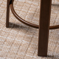 Close-up of a wooden stool leg and curved footrest