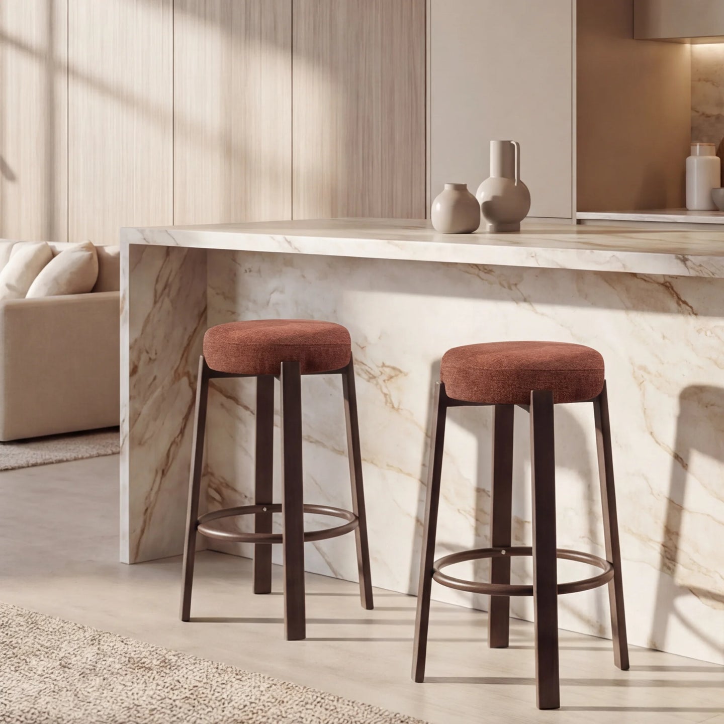 Two bar stools with round rust-brown upholstered seats and dark metal legs