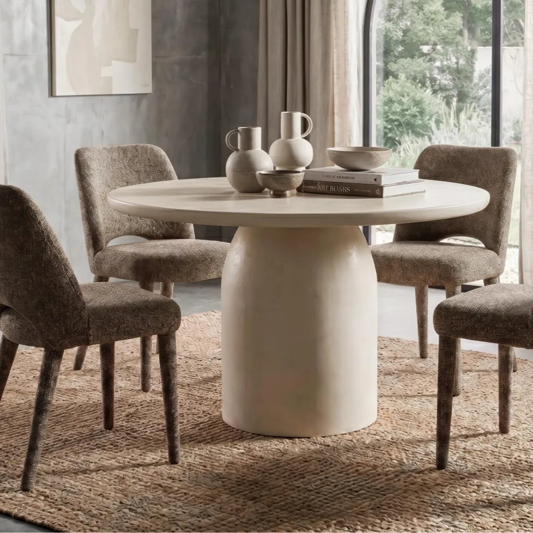 Calisto 1.2m Pebble round dining table with matte micro-cement finish and cylindrical pedestal base, with amphi chairs