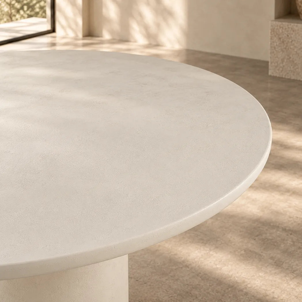 Calisto 1.2m Pebble round dining table with matte micro-cement finish and cylindrical pedestal base, close up view
