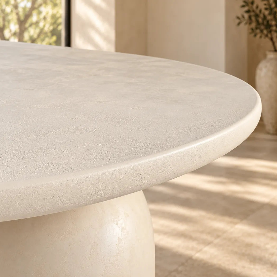 Calisto Pebble oval dining table with micro-cement finish and two cylindrical pedestal bases, close up view
