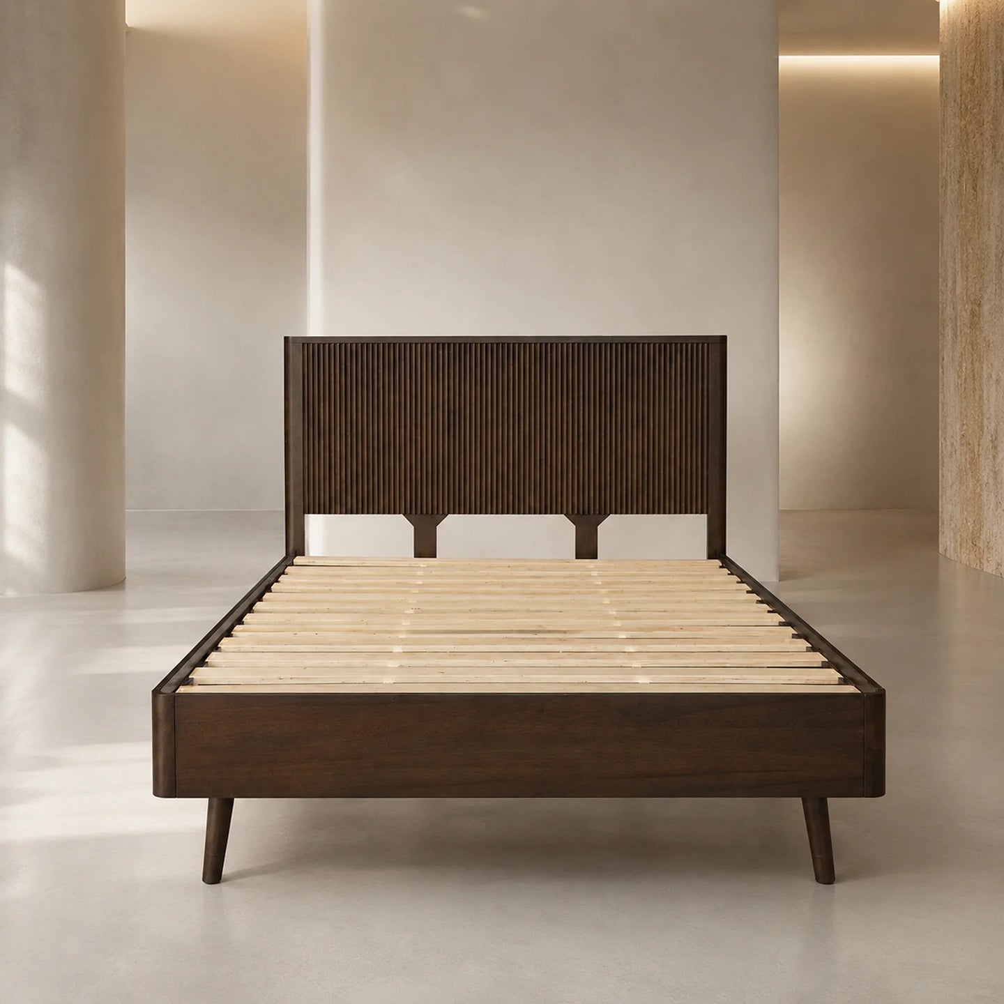 A modern dark brown wooden bed frame with a ribbed headboard and light natural wood slats, shown in a minimalist, warm-toned interior setting.