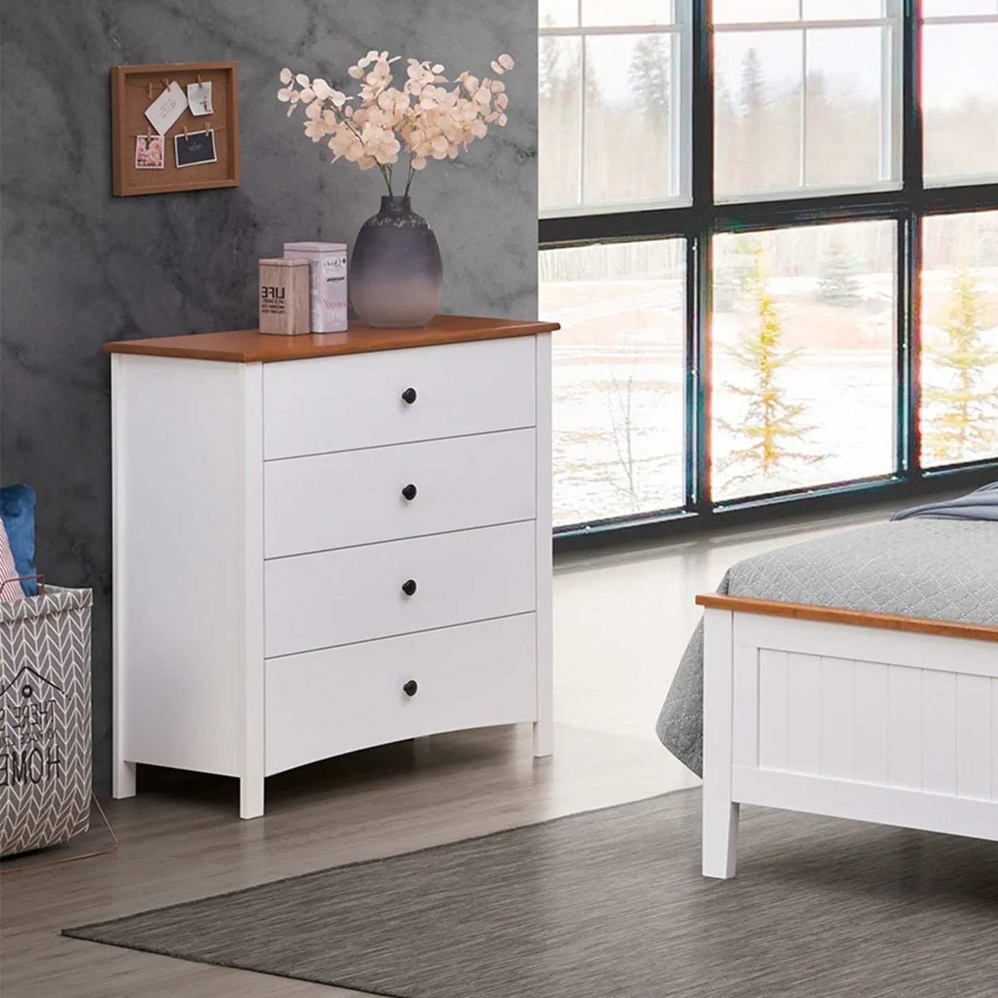 White dresser with wooden top in a bedroom setting with large windows.
