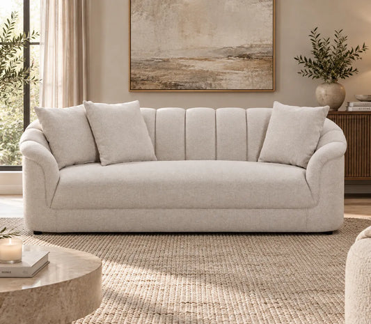 Eastwood beige 3 seater sofa with curved arms, vertical channelled backrest and three scatter cushions, front view