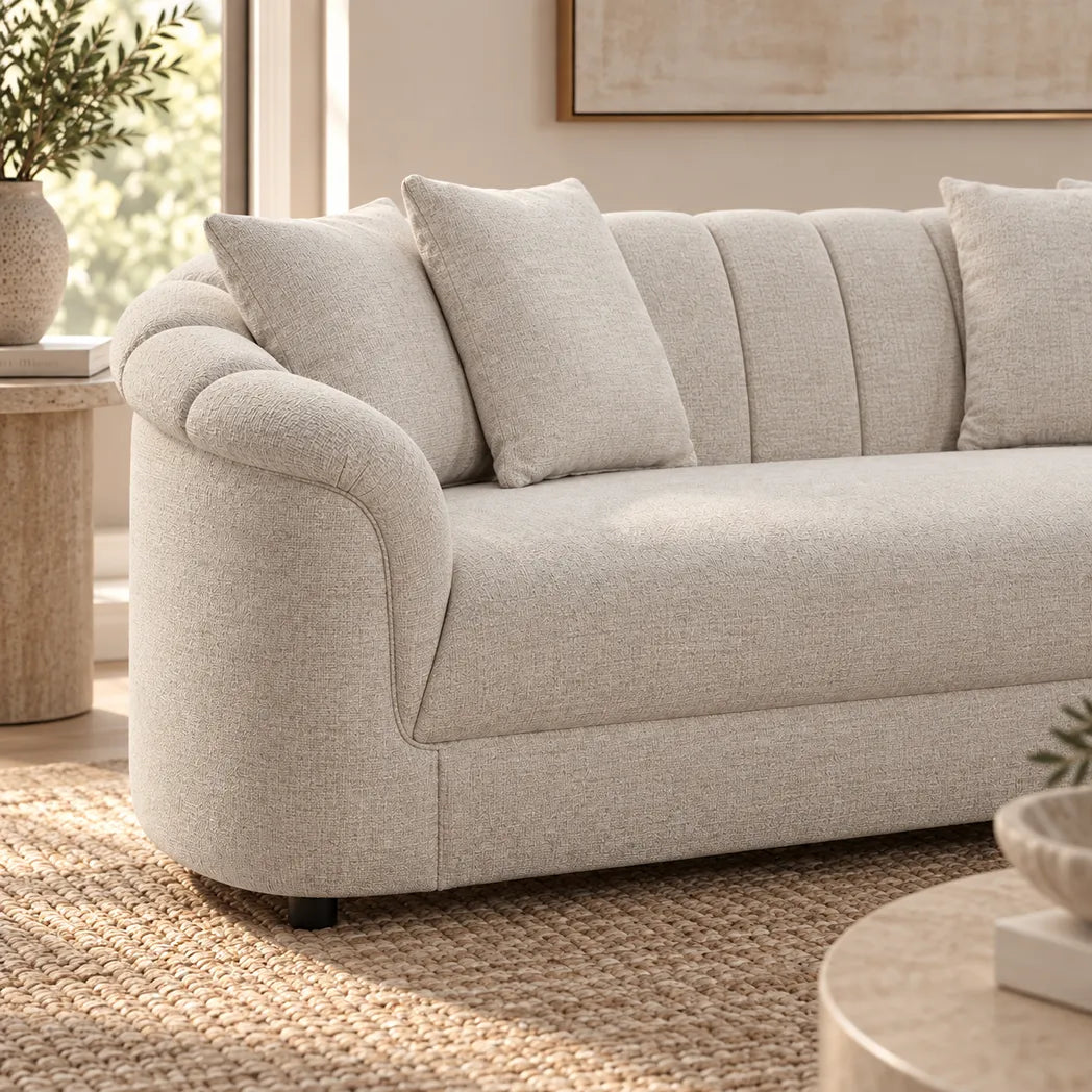 Eastwood beige 4 seater sofa with curved arms, vertical channelled backrest and four scatter cushions, side view