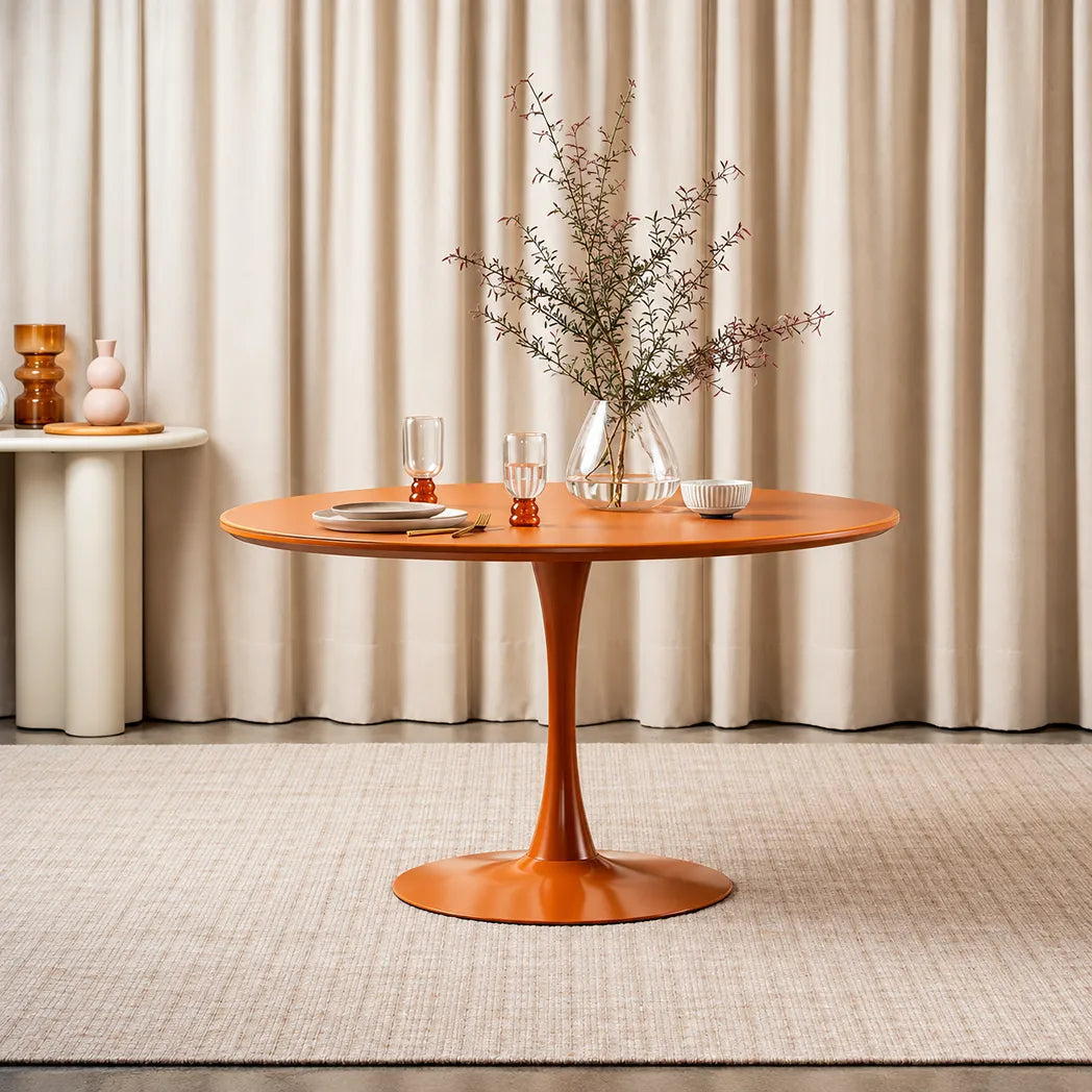 Elan 1.2m Matte Orange round dining table with matte tempered glass top and powder-coated metal pedestal base, front view
