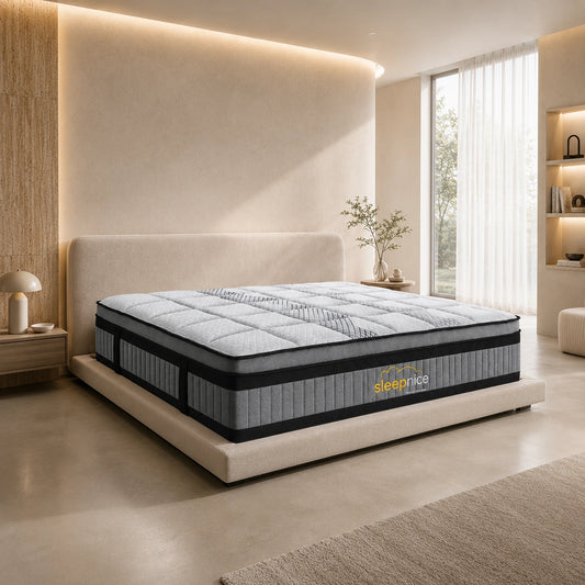 A high-end bed with a thick, quilted mattress and a matching upholstered platform bed frame, styled in a modern, warm-toned bedroom setting with built-in wood shelving and ambient lighting.