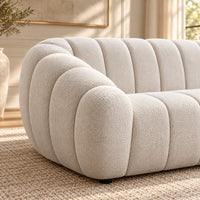 Kenya Beige 4 seater sofa with curved low-profile design, slanted arms and vertical panel detailing, side view