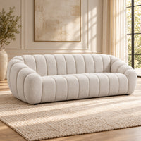 Kenya Beige 4 seater sofa with curved low-profile design, slanted arms and vertical panel detailing, angled view