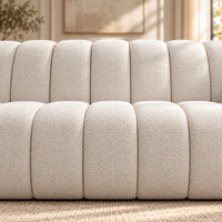 Kenya Beige 4 seater sofa with curved low-profile design, slanted arms and vertical panel detailing, close up view