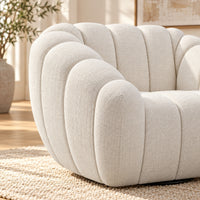 Kenya Beige swivel armchair with curved low-profile design, slanted arms and vertical panel detailing, close up view
