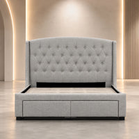 A light gray upholstered bed frame with a tall tufted headboard and two storage drawers at the foot, shown in a modern bedroom setting with warm ambient lighting.