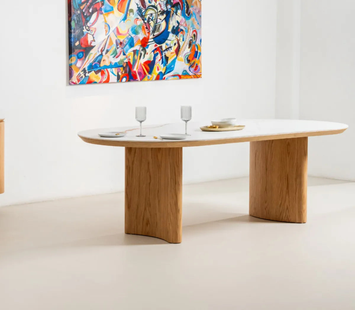 Lucerne natural ceramic dining table with matte white ceramic top and curved white oak veneer legs, angled view