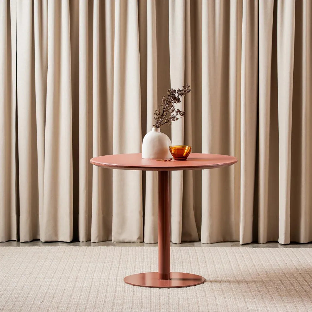 Positano 90cm Matte Rose round dining table with matte tempered glass top and powder-coated metal pedestal base, front view