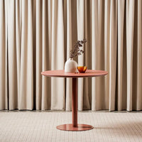 Positano 90cm Matte Rose round dining table with matte tempered glass top and powder-coated metal pedestal base, front view