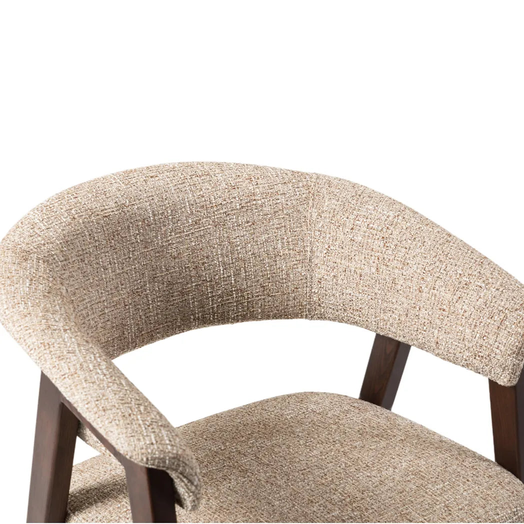 Close-up of Rovano modern upholstered dining chair with a curved backrest and seat, featuring a textured beige and brown woven fabric and dark wood legs.