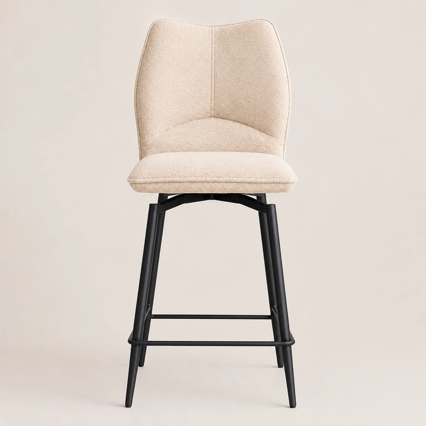 A modern bar stool with a curved, high-back upholstered seat in a textured cream fabric and a black metal frame with a footrest