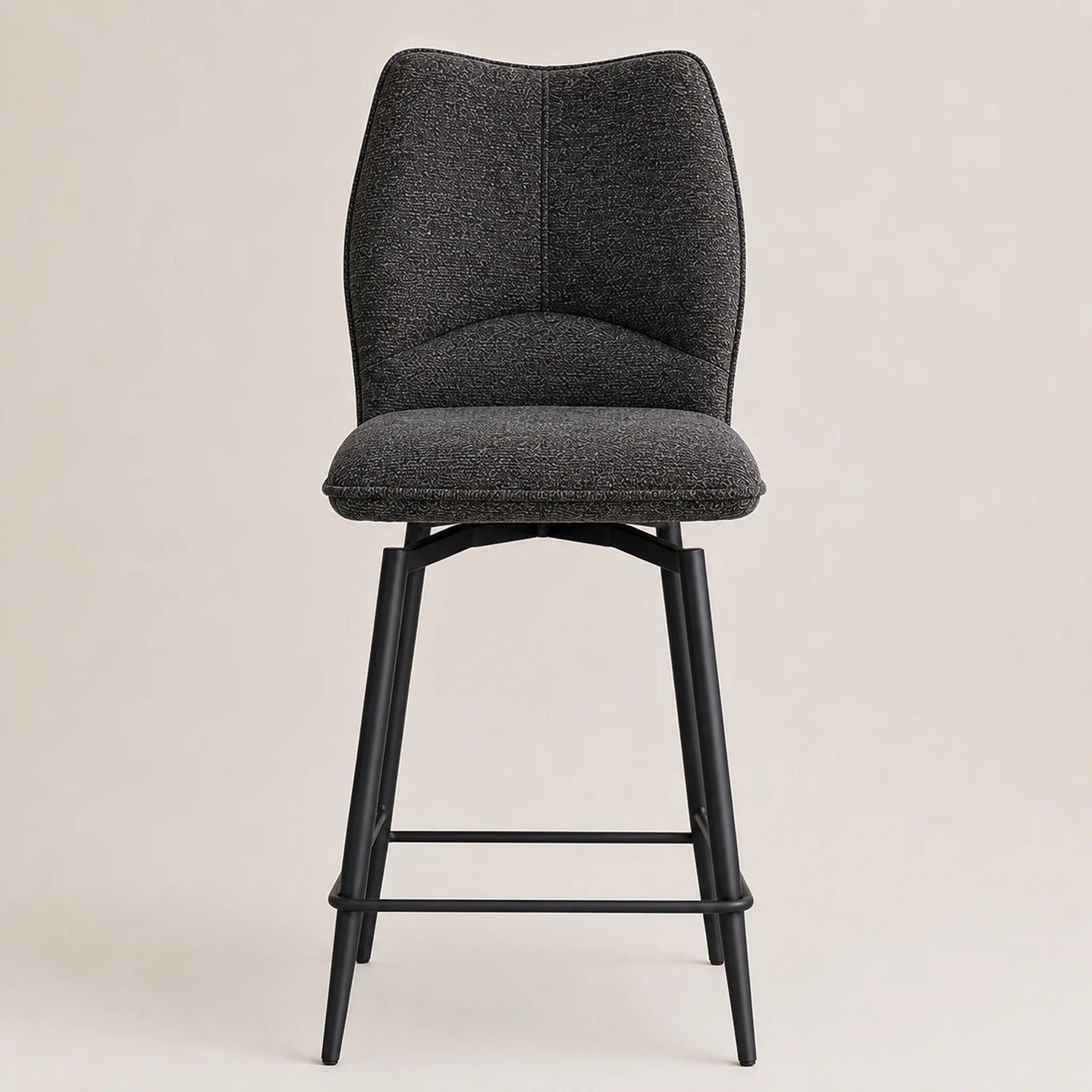A modern bar stool with a textured dark gray fabric upholstered seat and curved backrest, supported by a slim black metal frame with a footrest