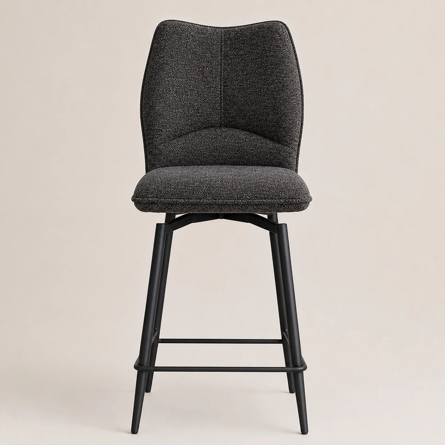 A modern bar stool with a textured dark gray fabric upholstered seat and curved backrest, supported by a slim black metal frame with a footrest