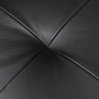 Close-up of black pebbled leather upholstery with stitched panel lines converging at the center.