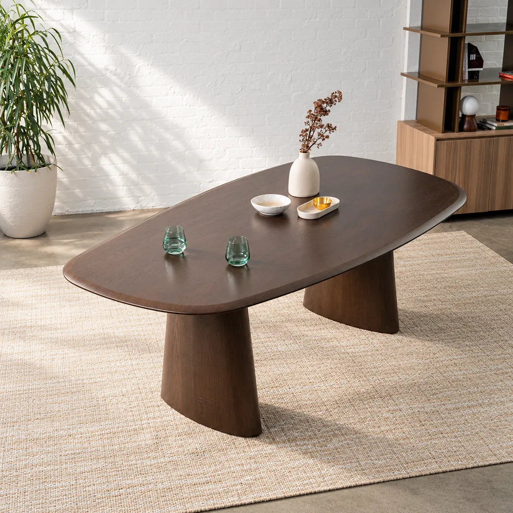 Tierra 2.2m Walnut dining table with sculptural asymmetrical ash veneer tabletop, softly rounded edges and curved pedestal legs, angled view