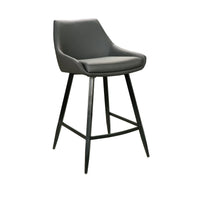 A modern bar stool with a dark gray upholstered seat and curved backrest, supported by four tapered black metal legs with a central footrest, shown on a plain white background.