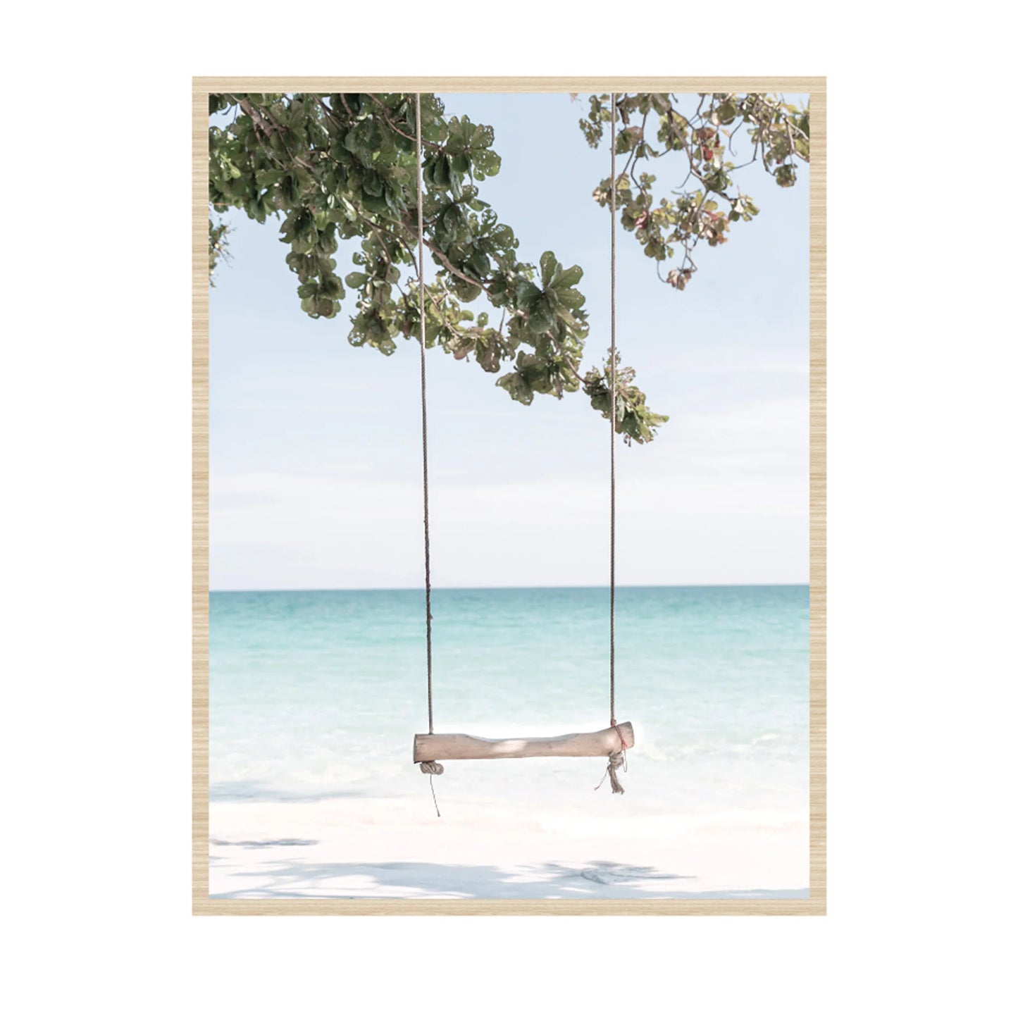 A framed art print depicting a wooden swing hanging from a tree over a tropical beach with turquoise water and white sand, set against a light gray background.
